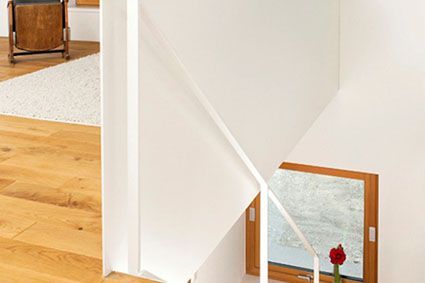 Auf der Treppe steht eine Blume in einer Vase.