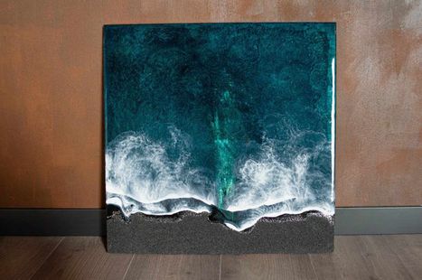 Pintura abstracta de paisaje marino en tonos verde azulado y blanco sobre una pared marrón encima de un suelo de madera.
