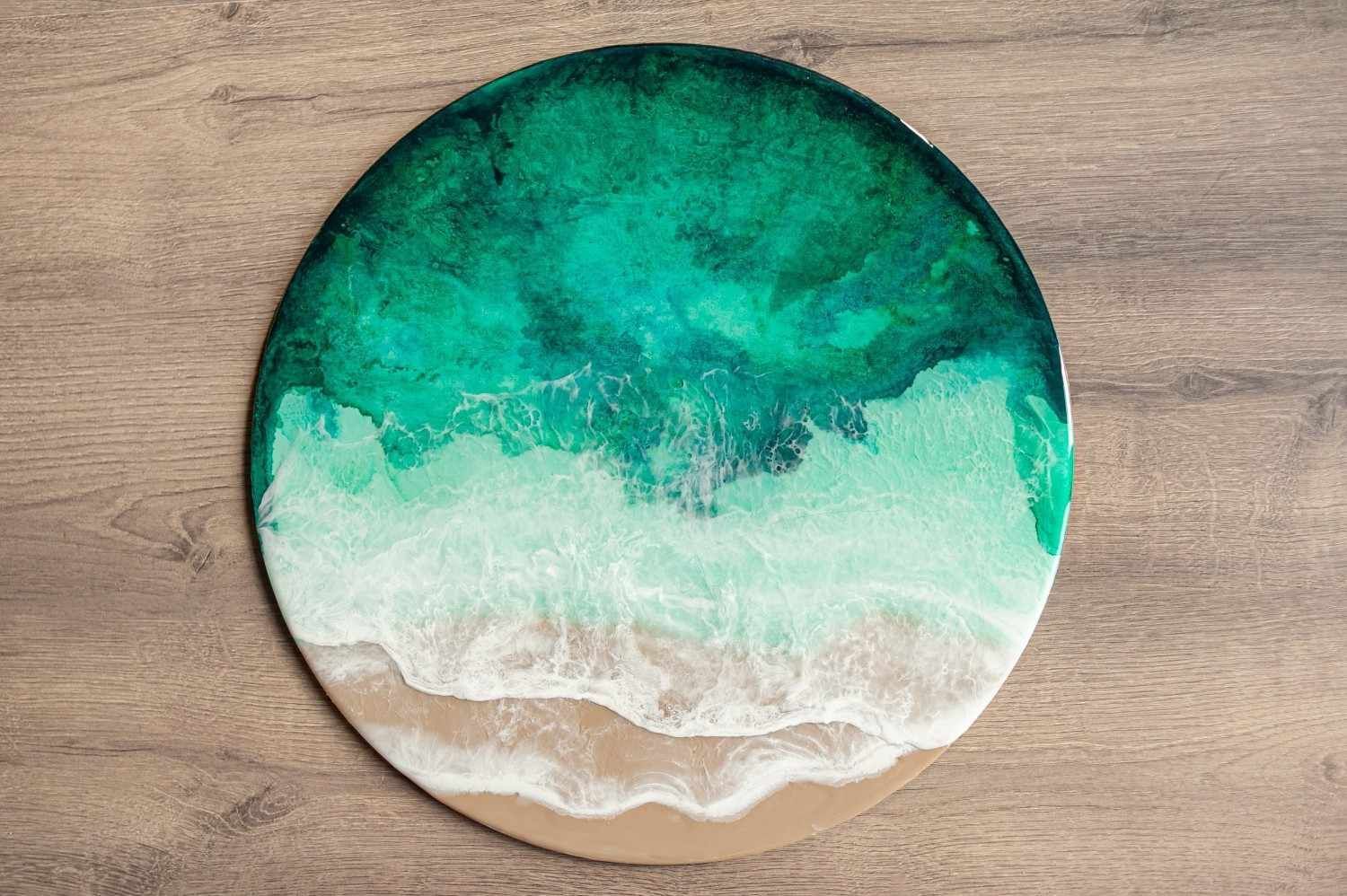 Obra de arte redonda de resina de color verde azulado y blanco que se asemeja 