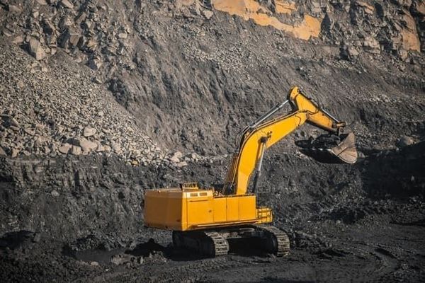 Una excavadora amarilla está trabajando en una mina de carbón.