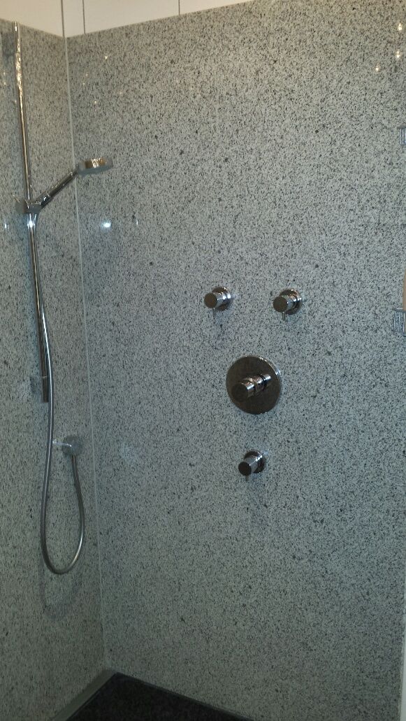 Dusche mit Natursteinwand nach der Renovierung