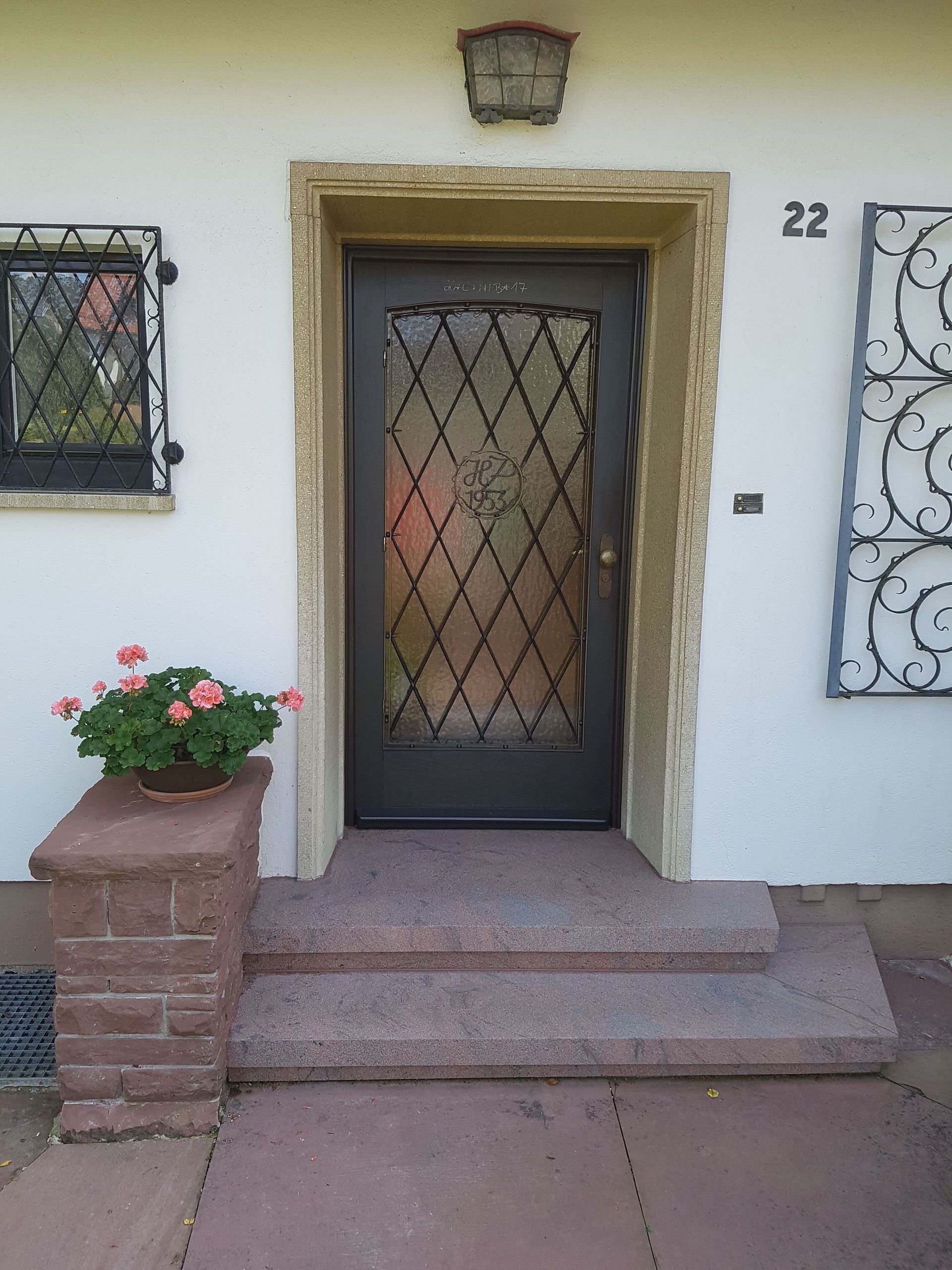 Eingangstür mit Glas- und Stahlelementen auf Natursteintreppe