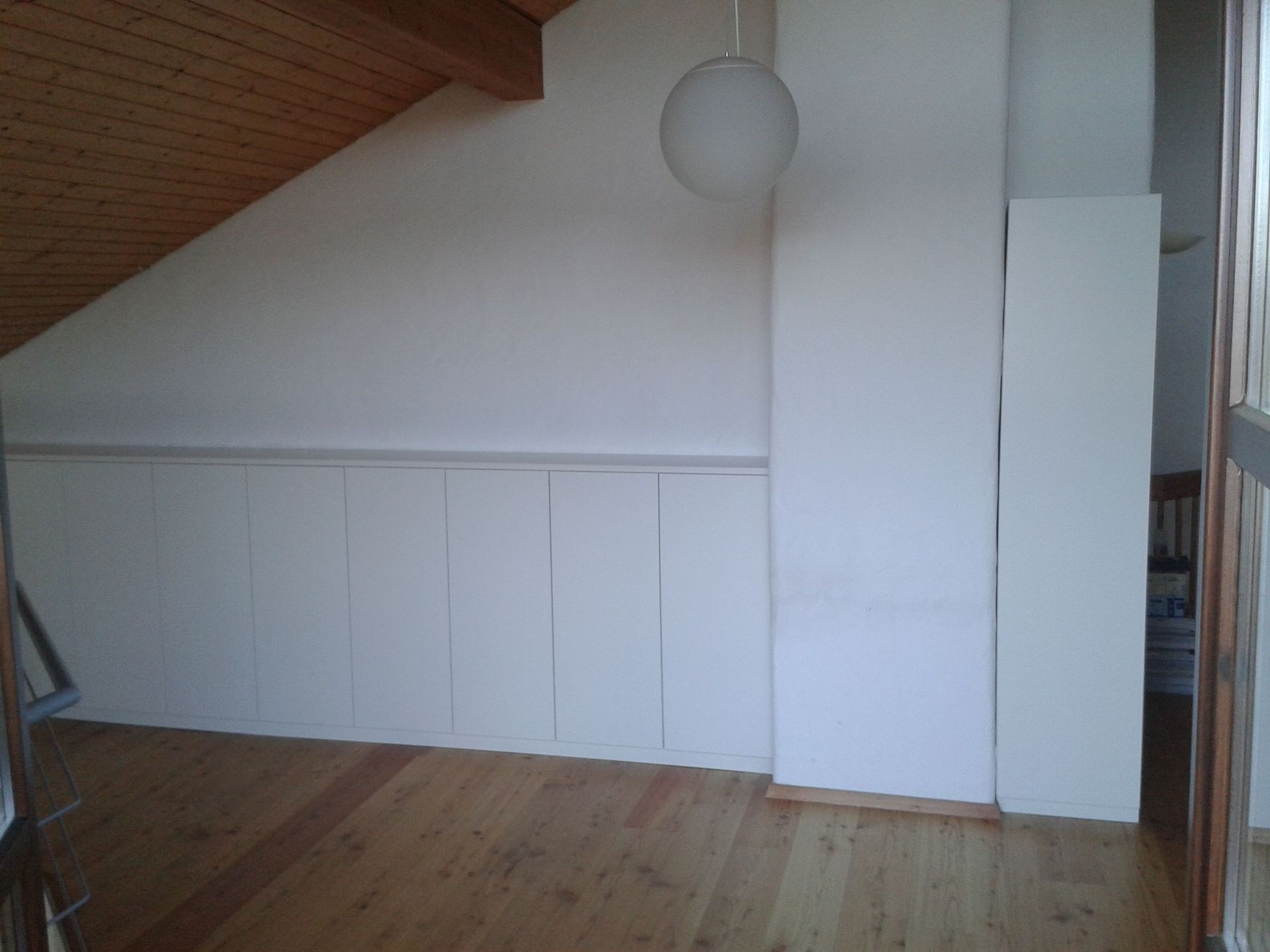 Raum mit hellen Wänden und Holzboden