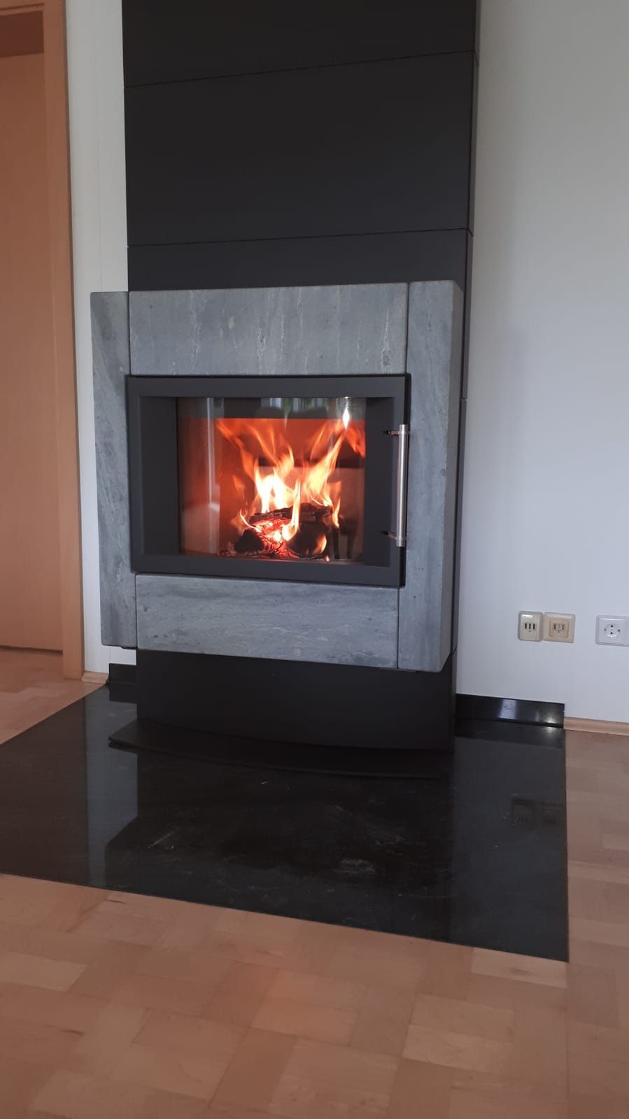 moderner Kamin mit dunkler Ofenplatte