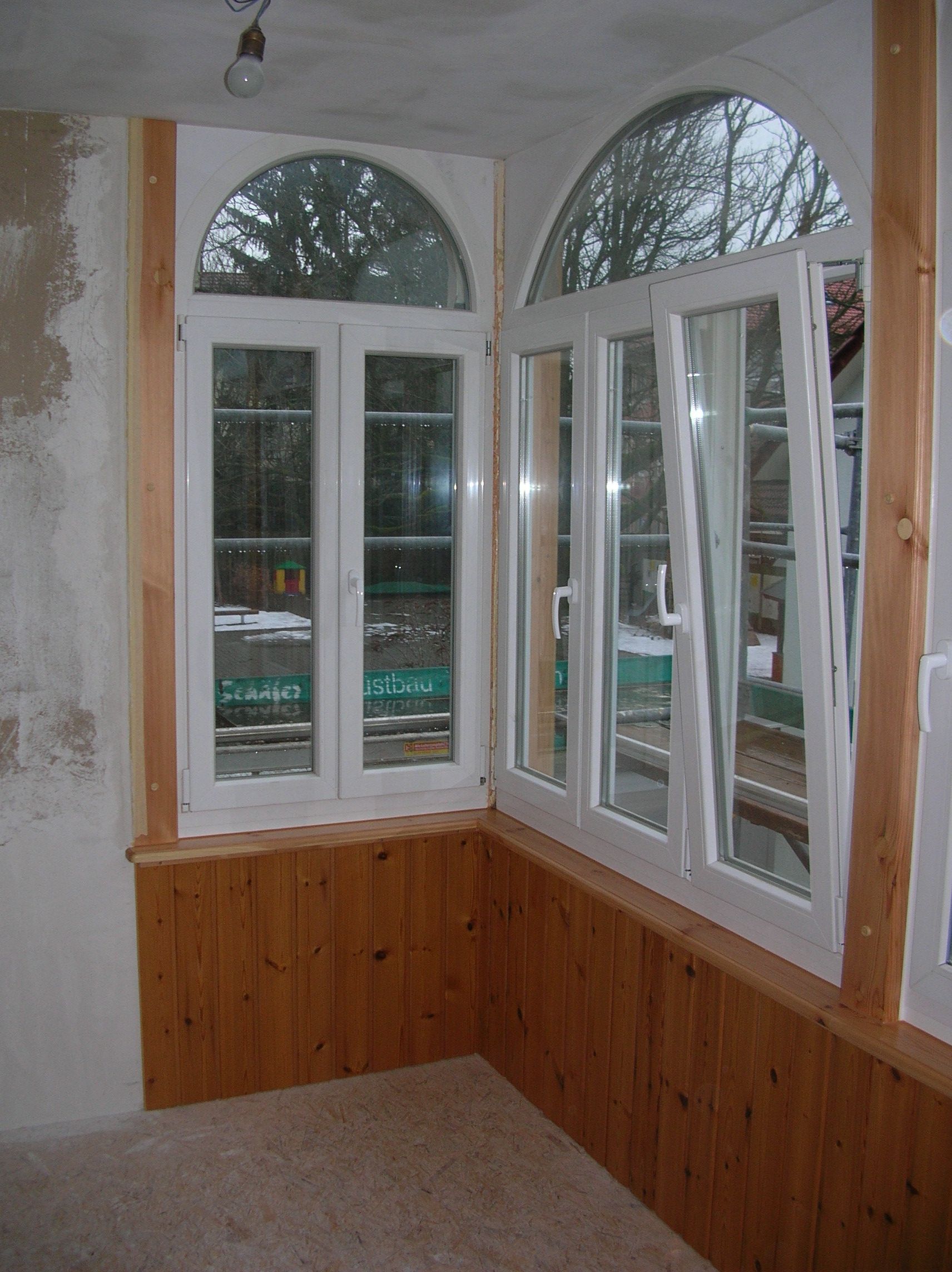 Renovierung eines Raums mit Holzwand und hellen Fenstern