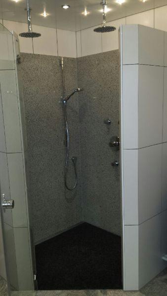 Dusche mit weißen Fliesen und Granitfassade