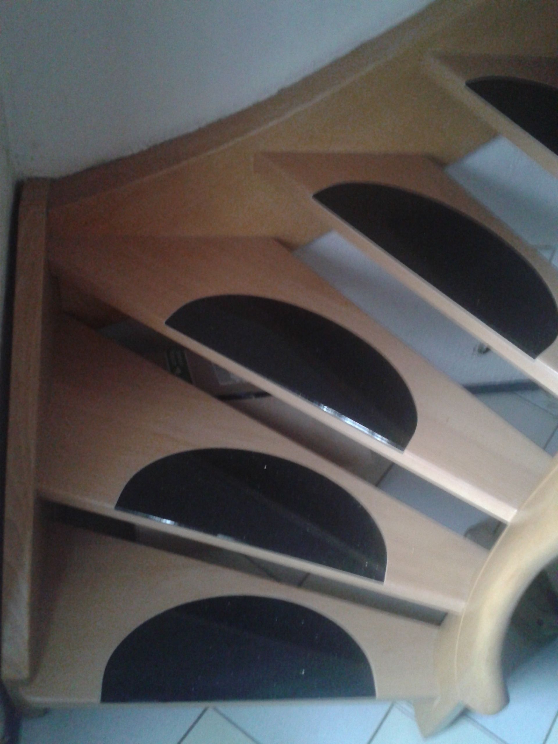 Holztreppe mit schwarzen Halbkreis-Elementen