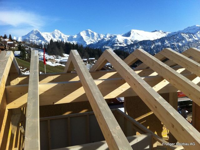 Parkettboden aus Holz mit quadratischem Muster in einem Raum mit weissen Wänden.