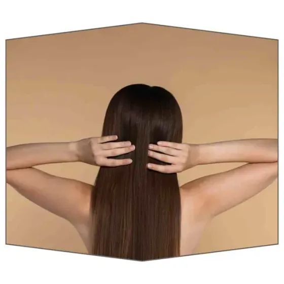 Mujer tocándose el pelo largo, liso y castaño, con los brazos extendidos, sobre un fondo tostado.