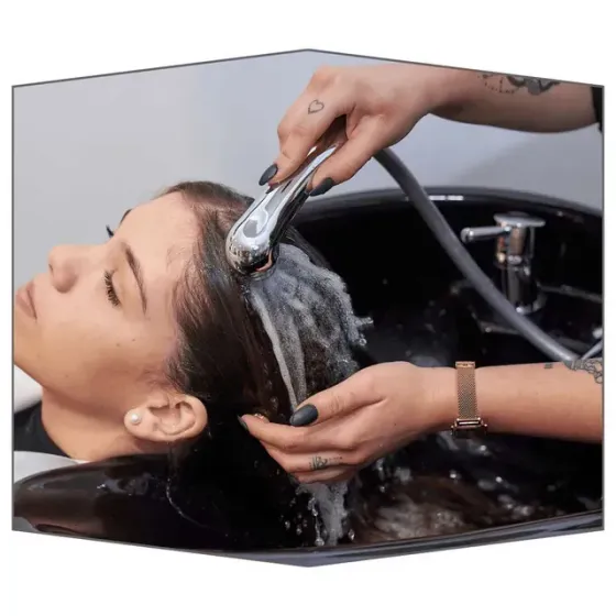 Mujer lavándose el pelo en el lavabo de una peluquería.