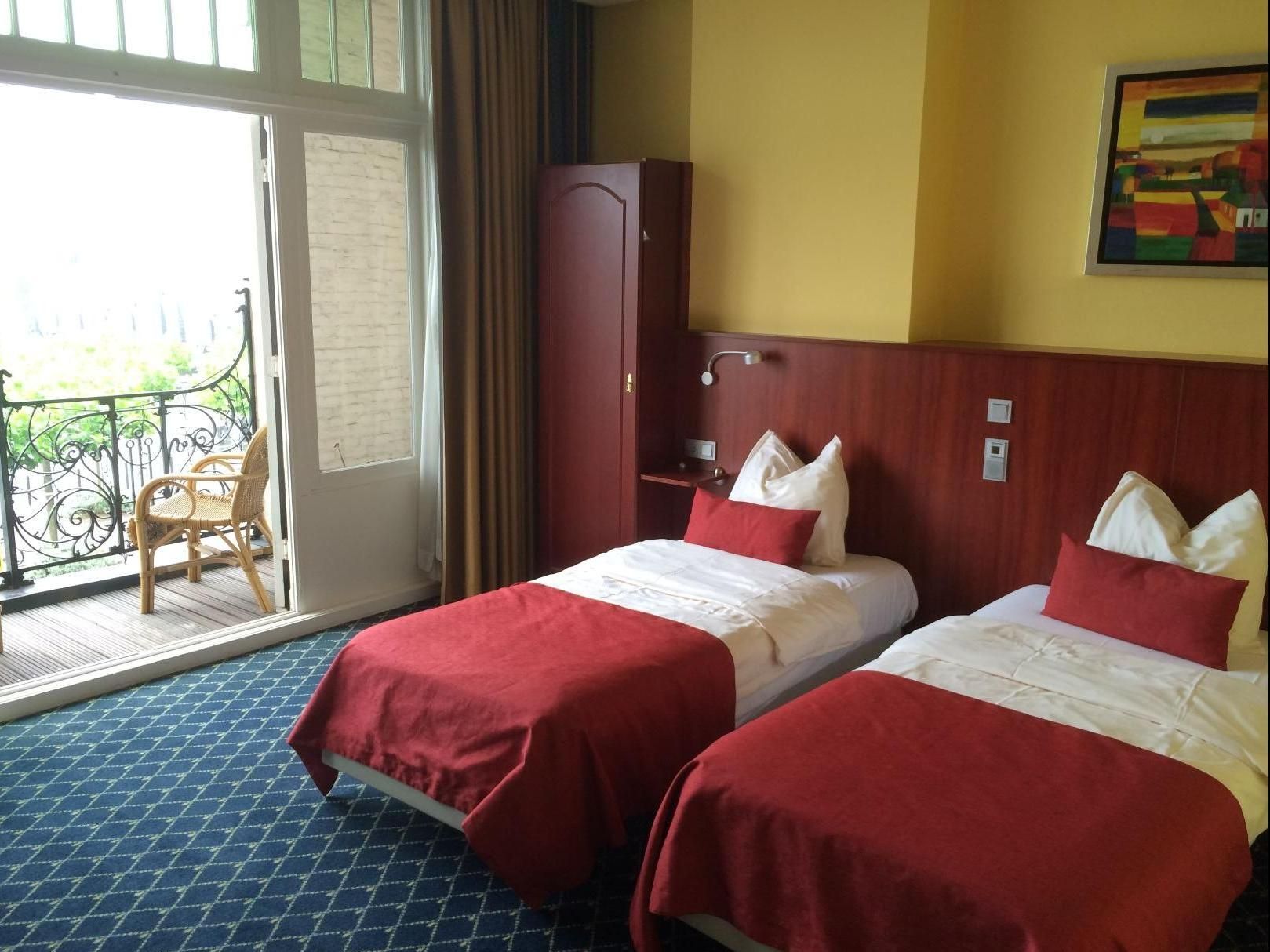 A hotel room with two beds and a balcony