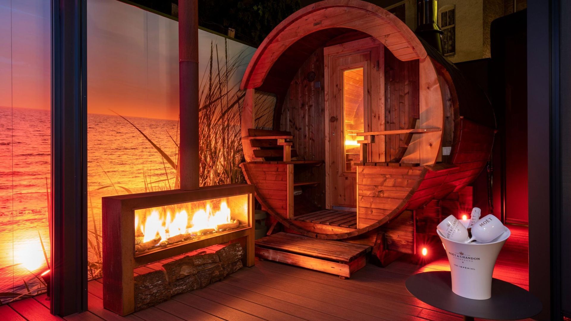 A wooden barrel is sitting on a wooden deck next to a fireplace.