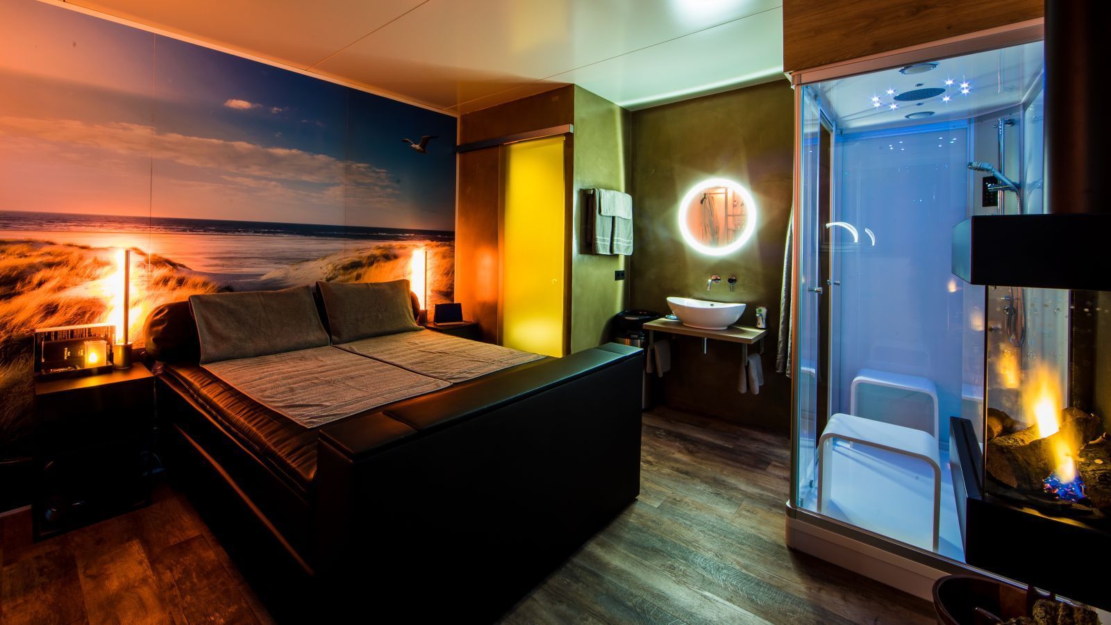 A bedroom with a large bed and a bathroom with a walk in shower.