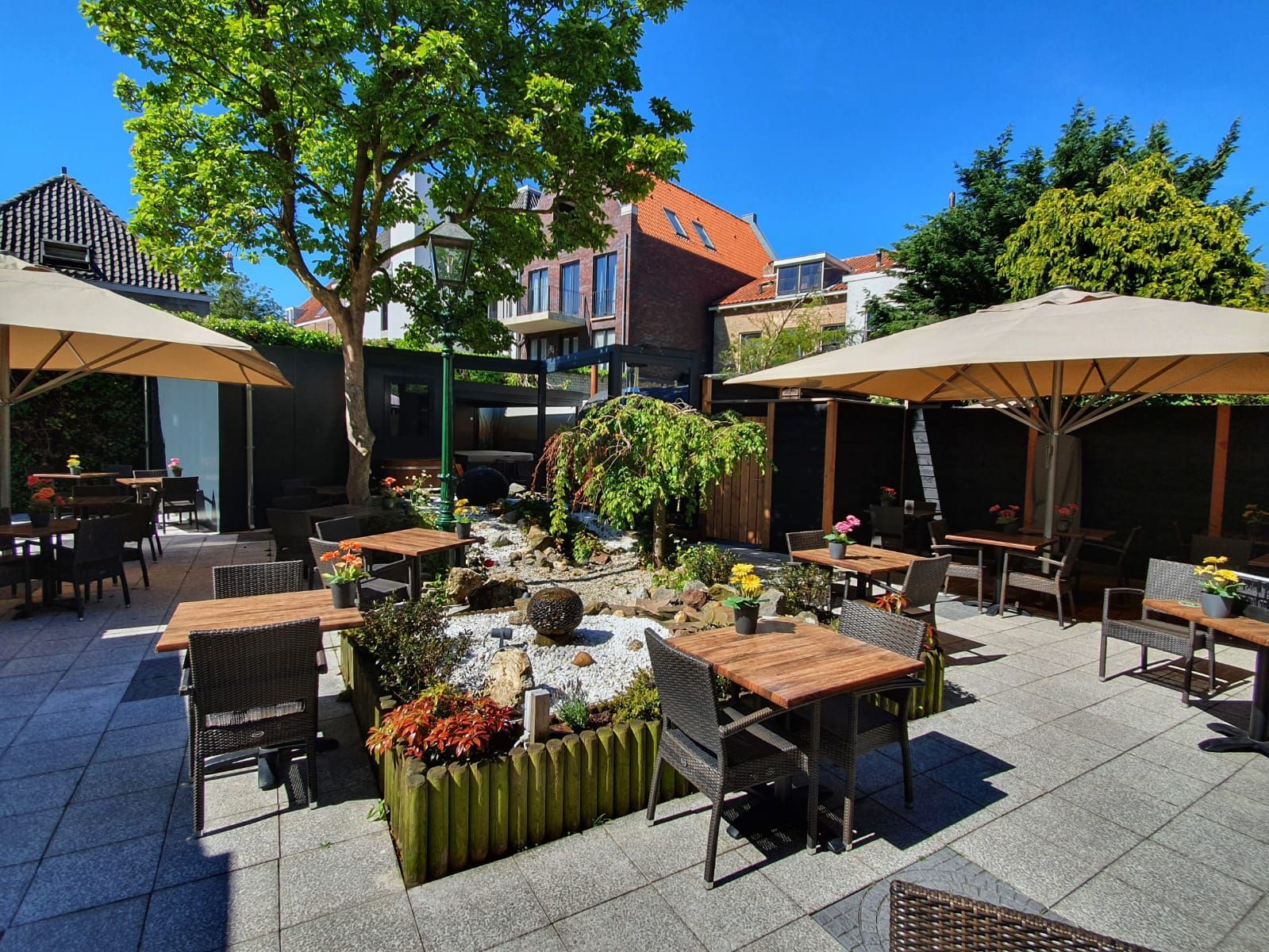 A patio with tables and chairs and umbrellas on a sunny day
