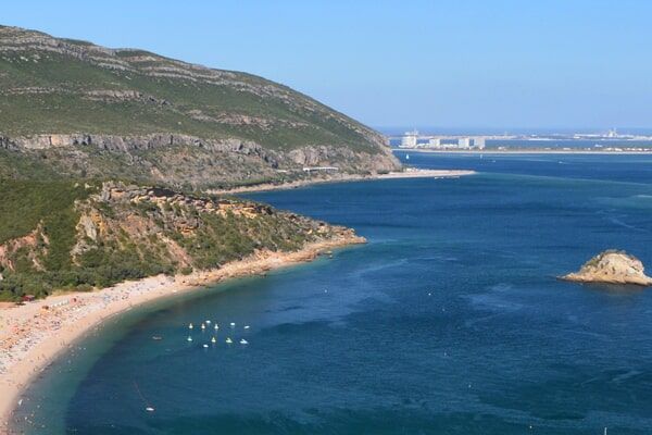 Uma vista ensolarada e pitoresca de Alcácer do Sal, Portugal, abaixo de uma colina.