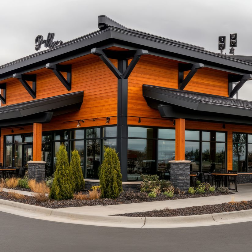 Restaurant avec bardage en bois orange, boiseries noires et grandes fenêtres.