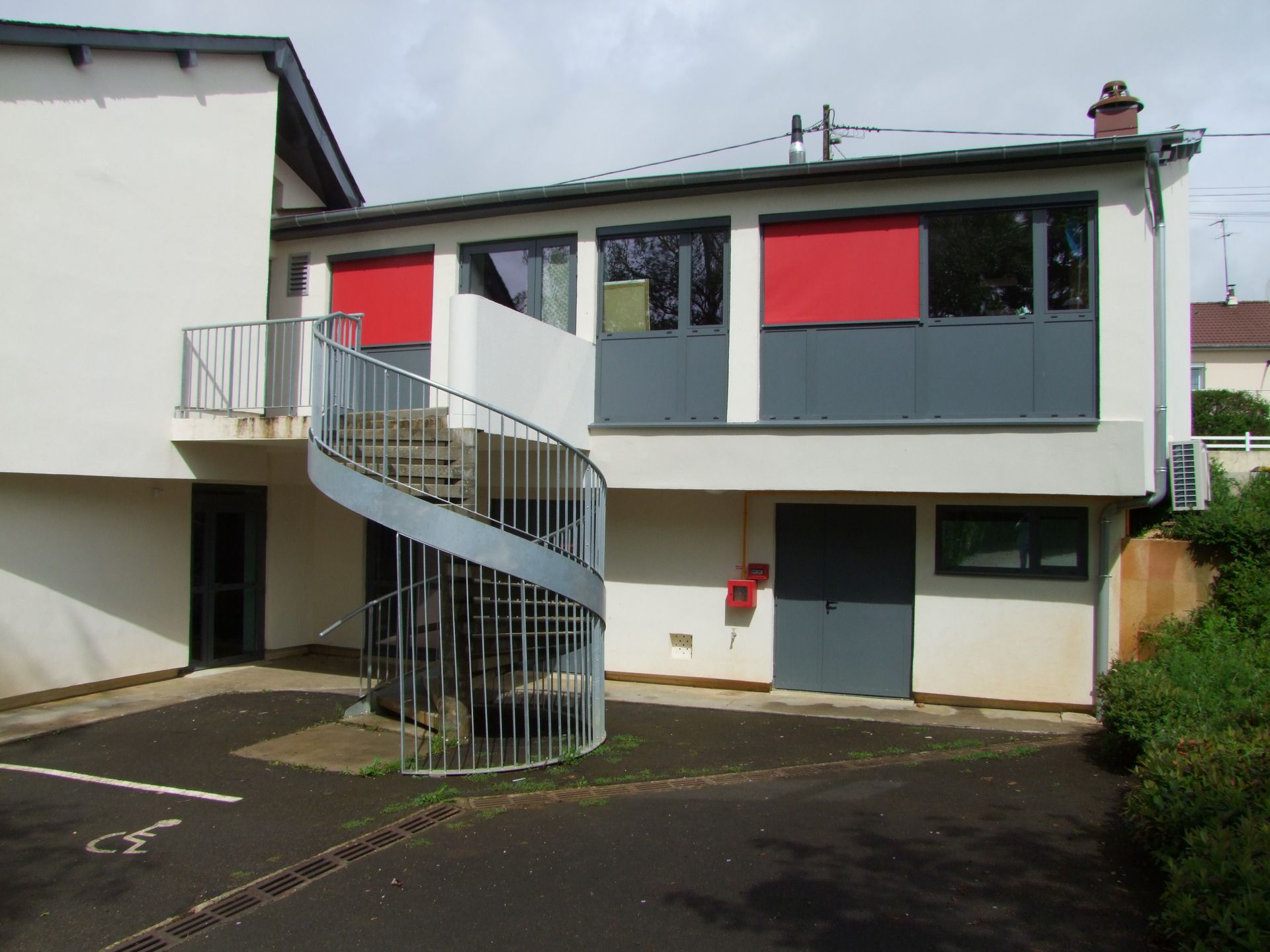 Une personne peint un mur au rouleau ; peinture bleue sur un mur blanc.