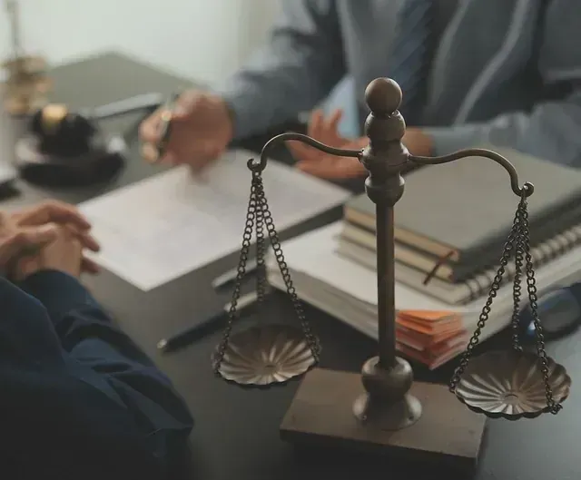 Una balanza de la justicia está sobre una mesa al lado de una pila de libros.
