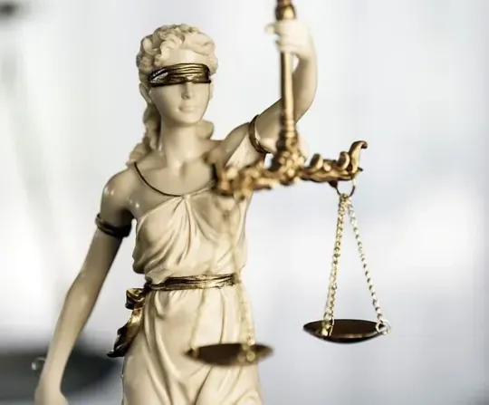 Una estatua de la Dama de la Justicia con los ojos vendados sosteniendo una balanza de la justicia.
