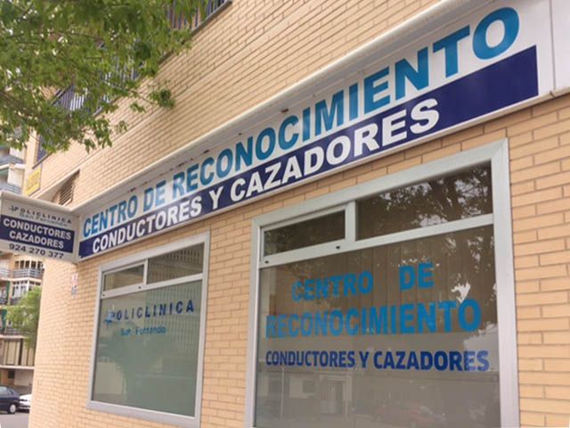 Letrero de entrada para un centro de reconocimiento de conductores y cazadores españoles en un edificio de ladrillo.