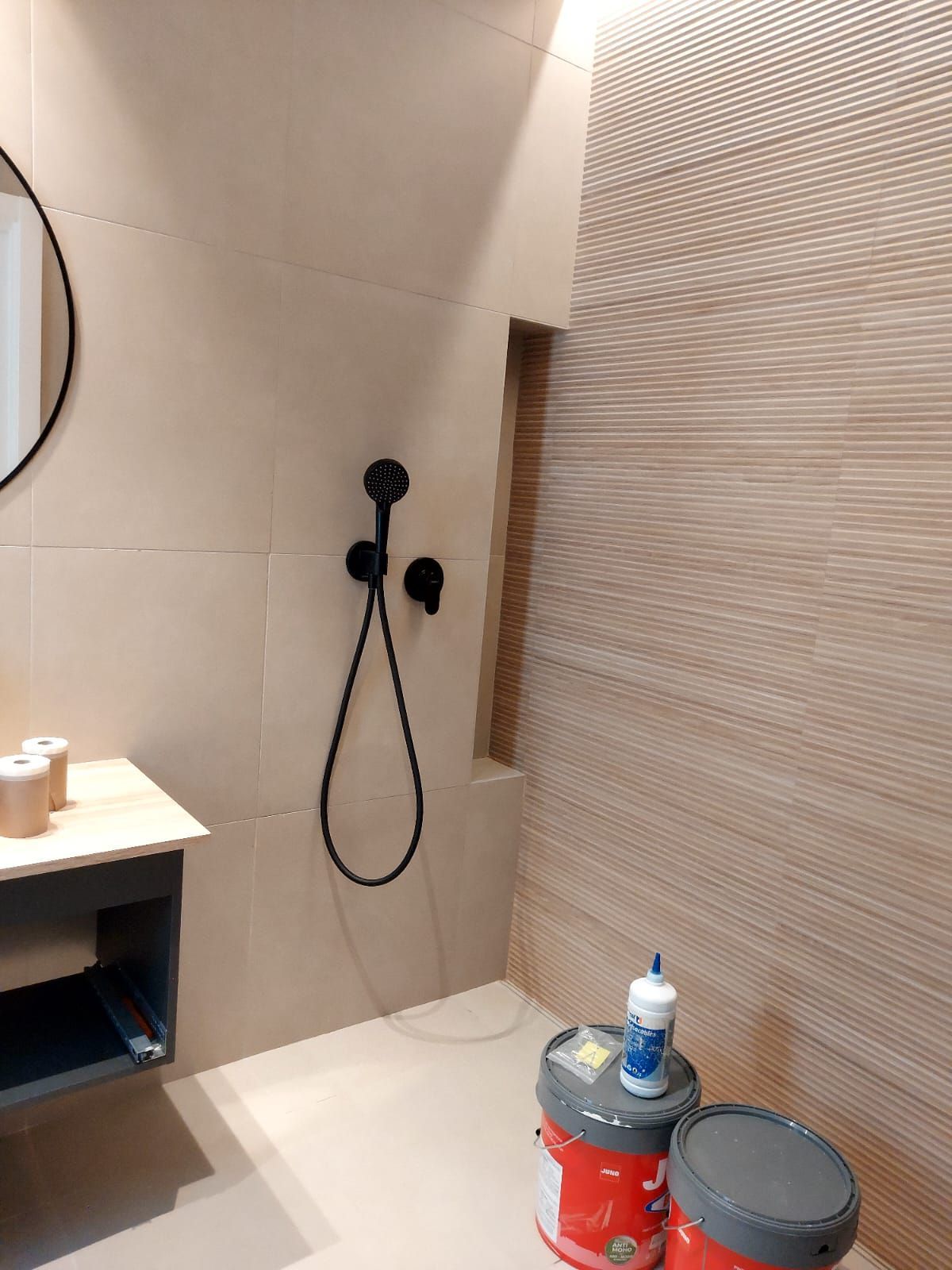 Un baño con ducha, lavabo y espejo.