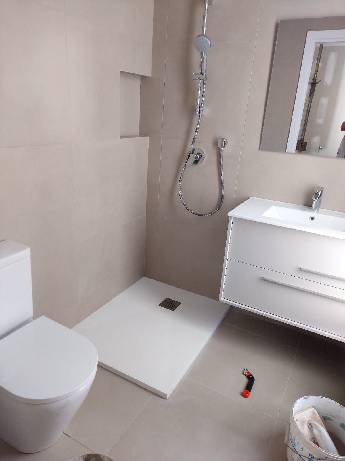 Un baño con inodoro, lavabo y ducha.