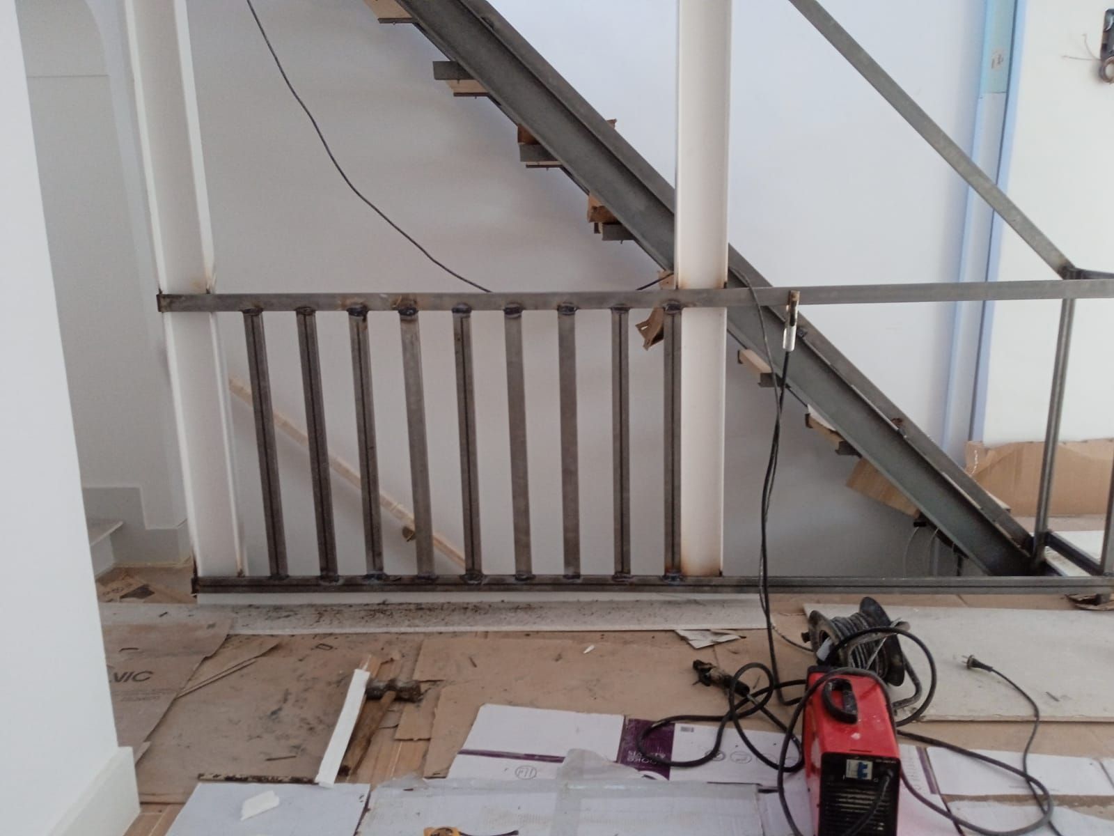 Una máquina de soldar está en el suelo junto a una escalera.