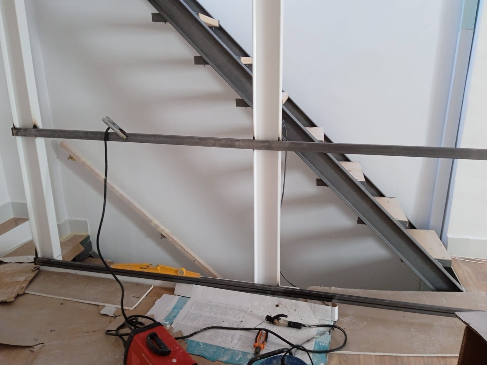 Se está construyendo una escalera en una habitación con una aspiradora en el suelo.