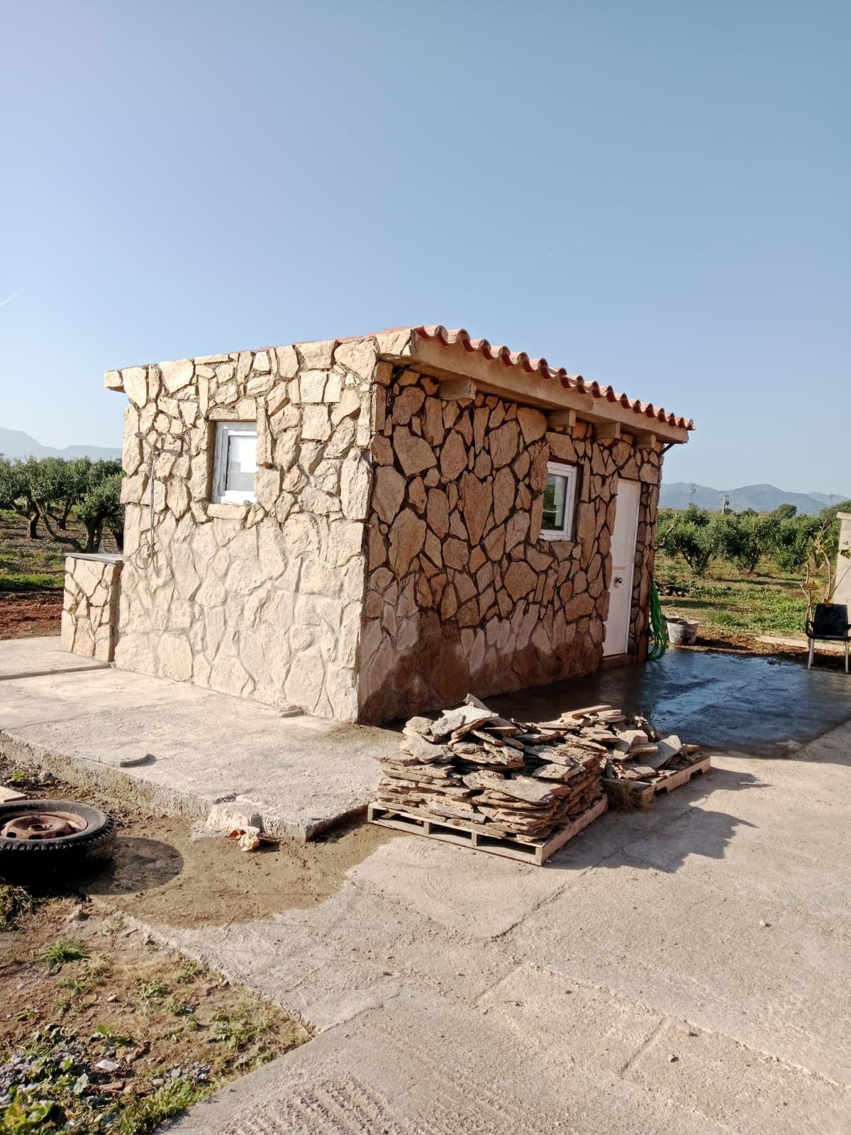 Se está construyendo un pequeño edificio de piedra con techo.
