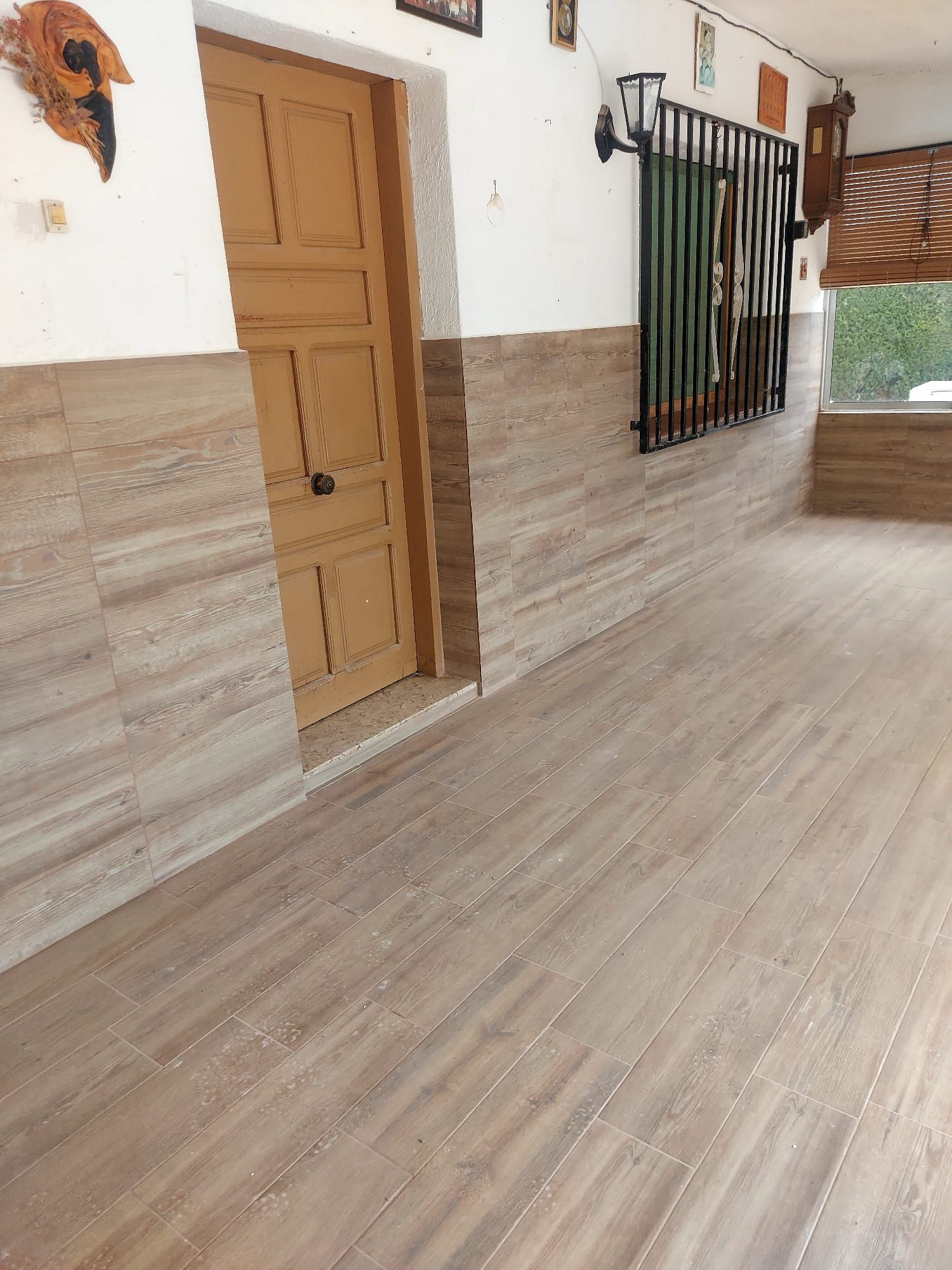 Un pasillo con suelo de madera y una puerta.