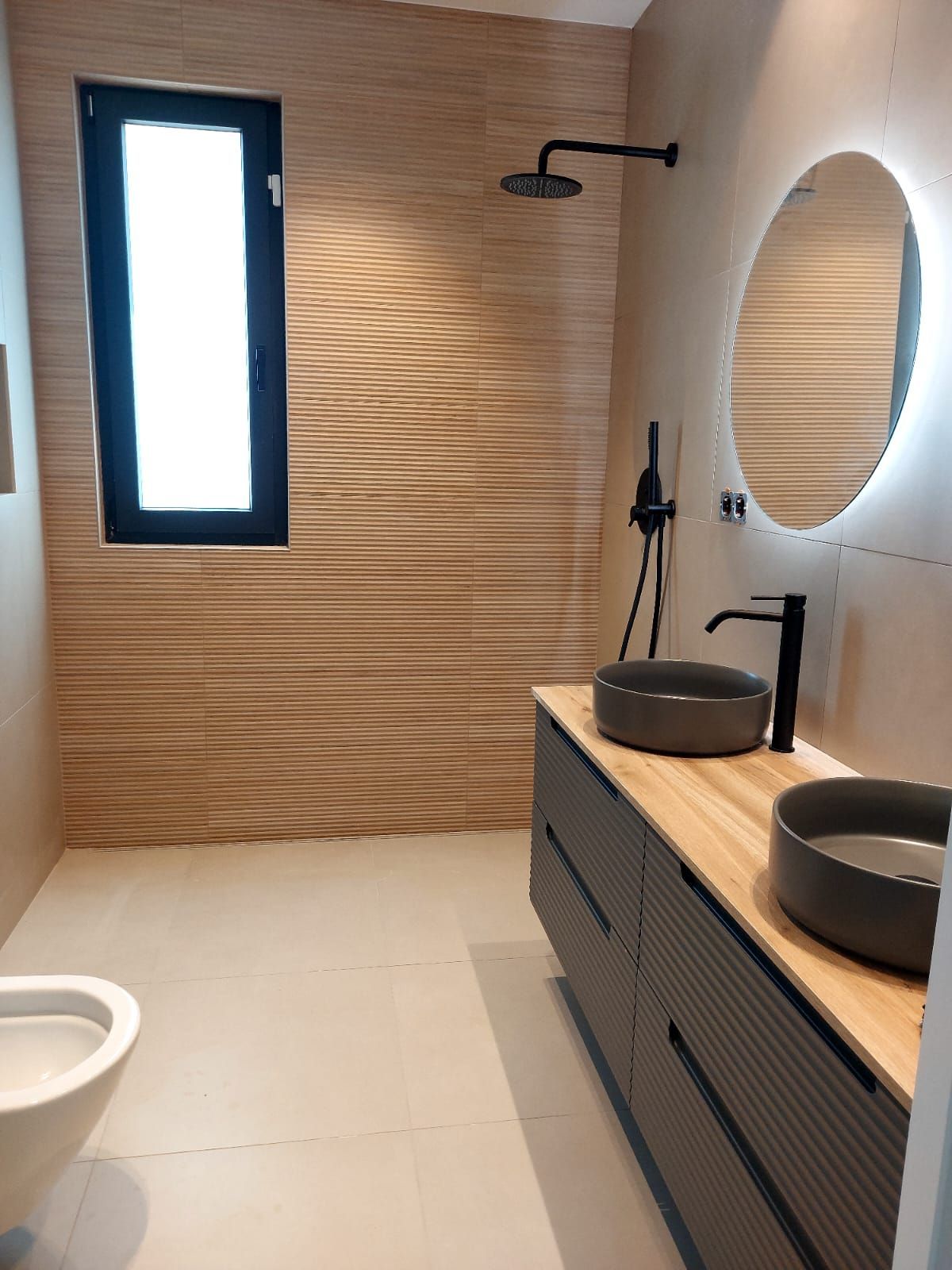 Un baño con dos lavabos, un inodoro y un espejo.