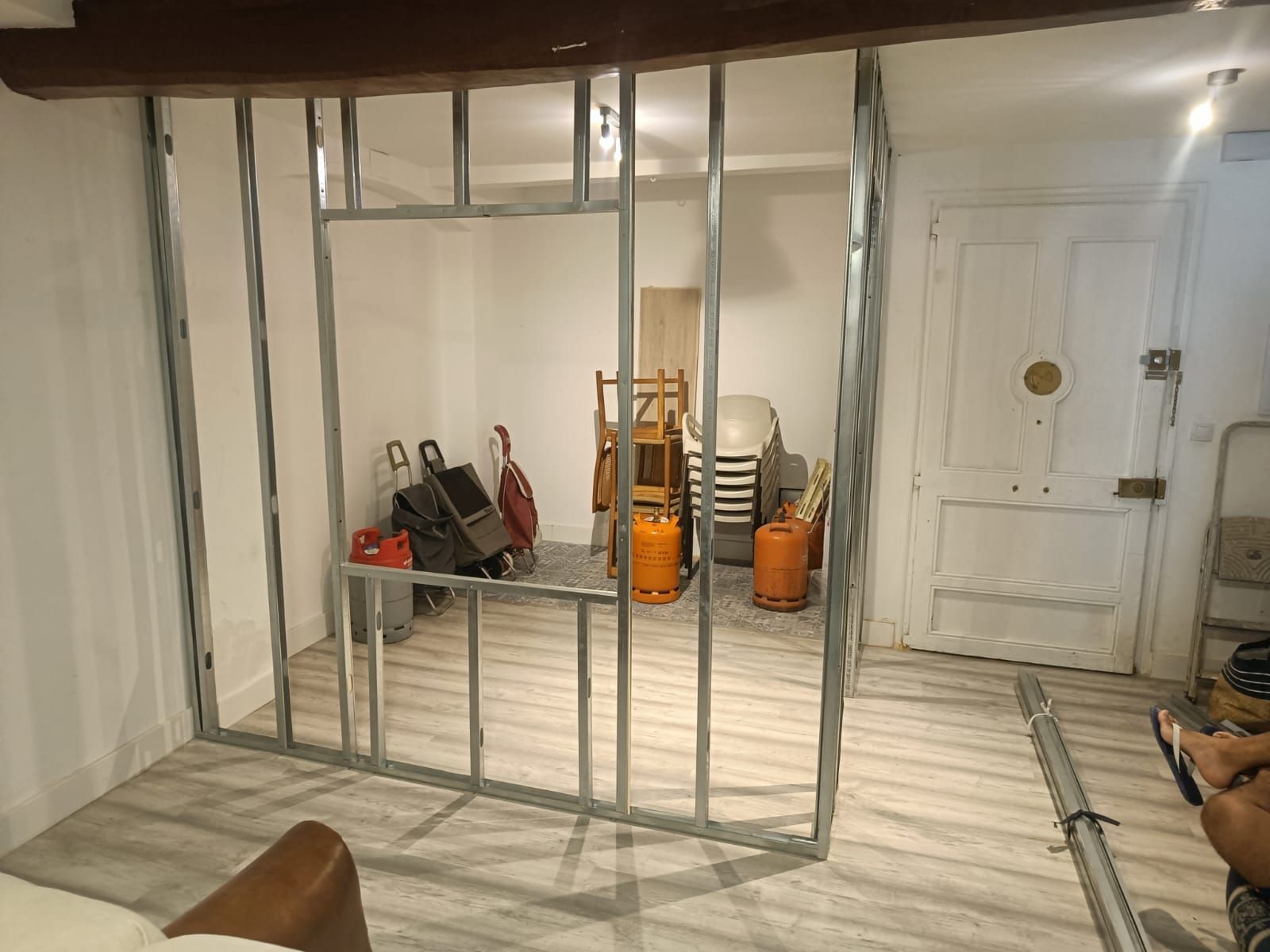 Una habitación con una partición hecha de marcos de metal y sillas.