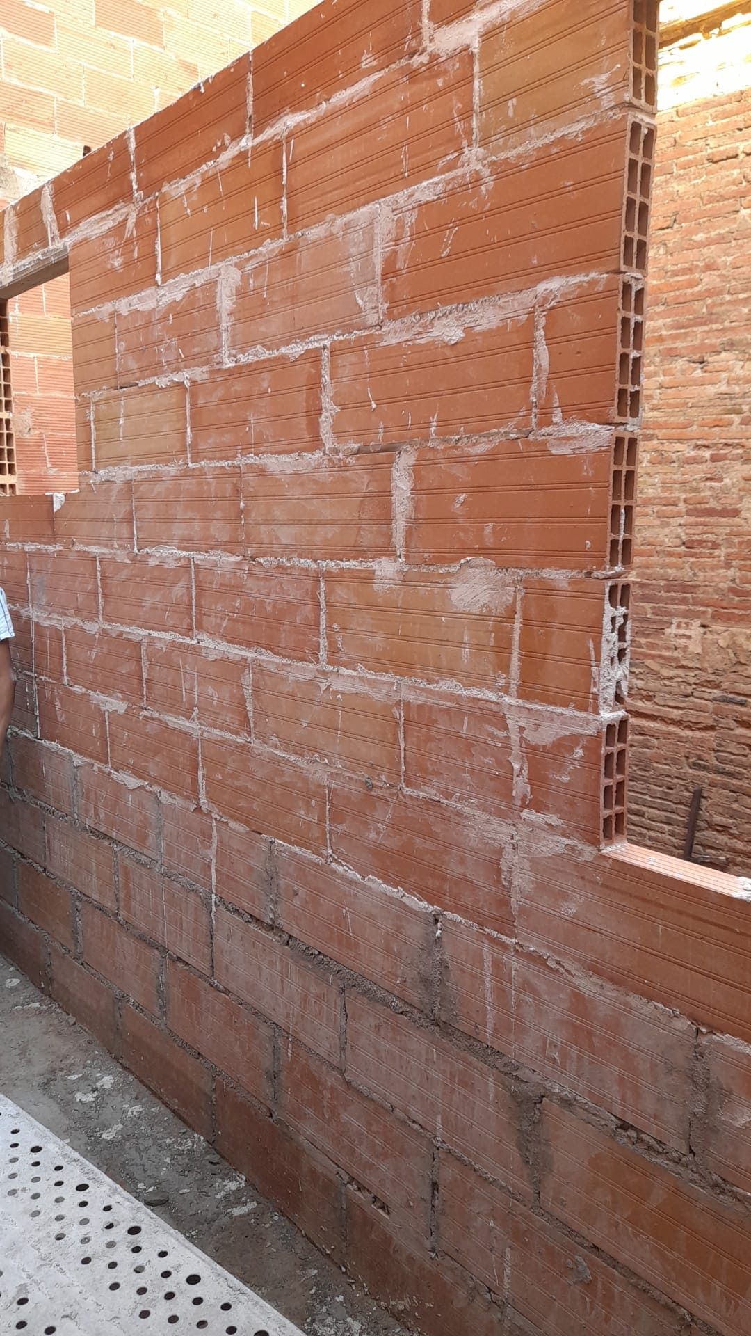 Se está construyendo un muro de ladrillos con una ventana.