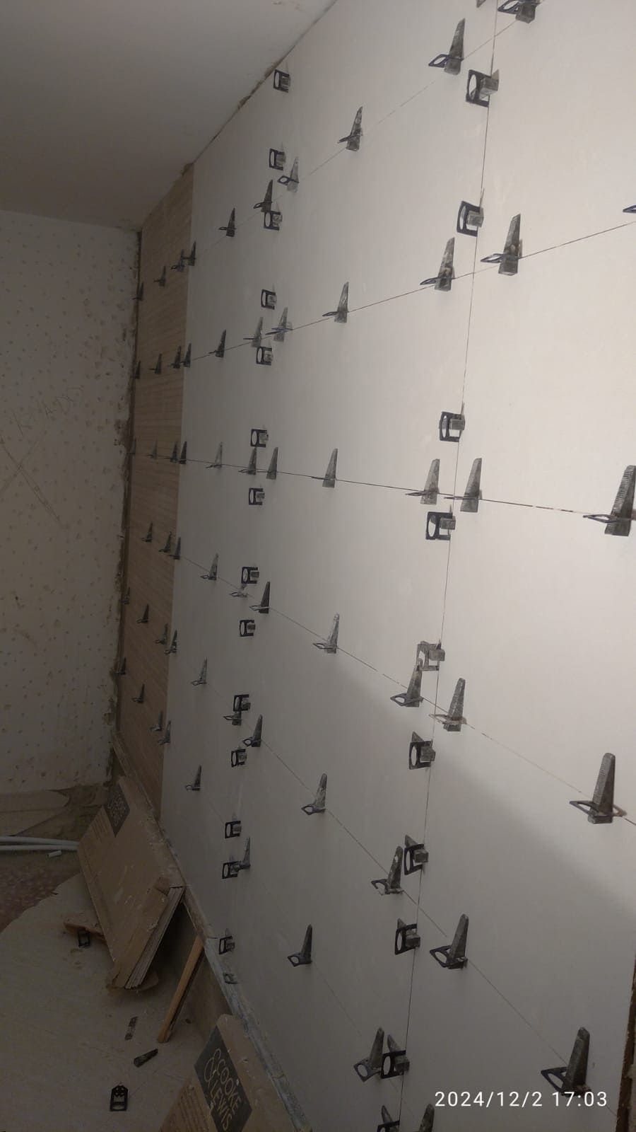 Se está alicatando una pared con muchos azulejos.