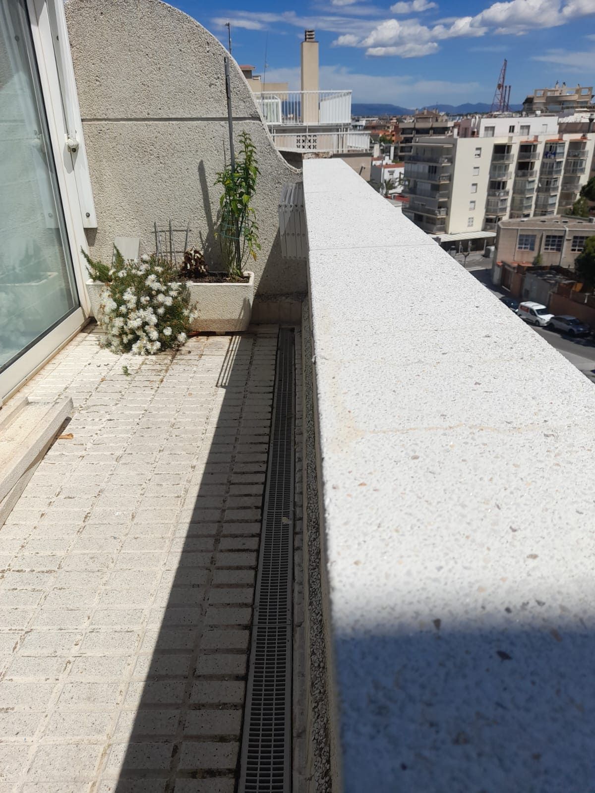 Un balcón con vista a una ciudad y un desagüe.