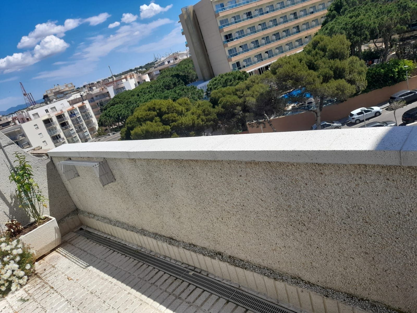 Un balcón con vista a una ciudad y árboles.