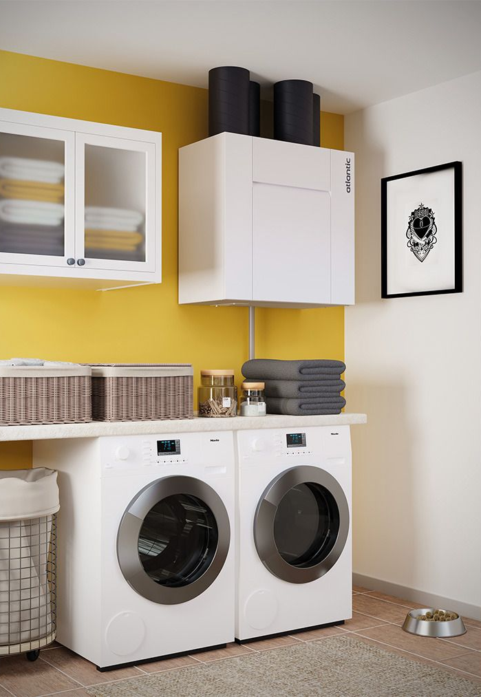 Buanderie moderne avec lave-linge et sèche-linge sous des placards blancs et des étagères sur un mur jaune