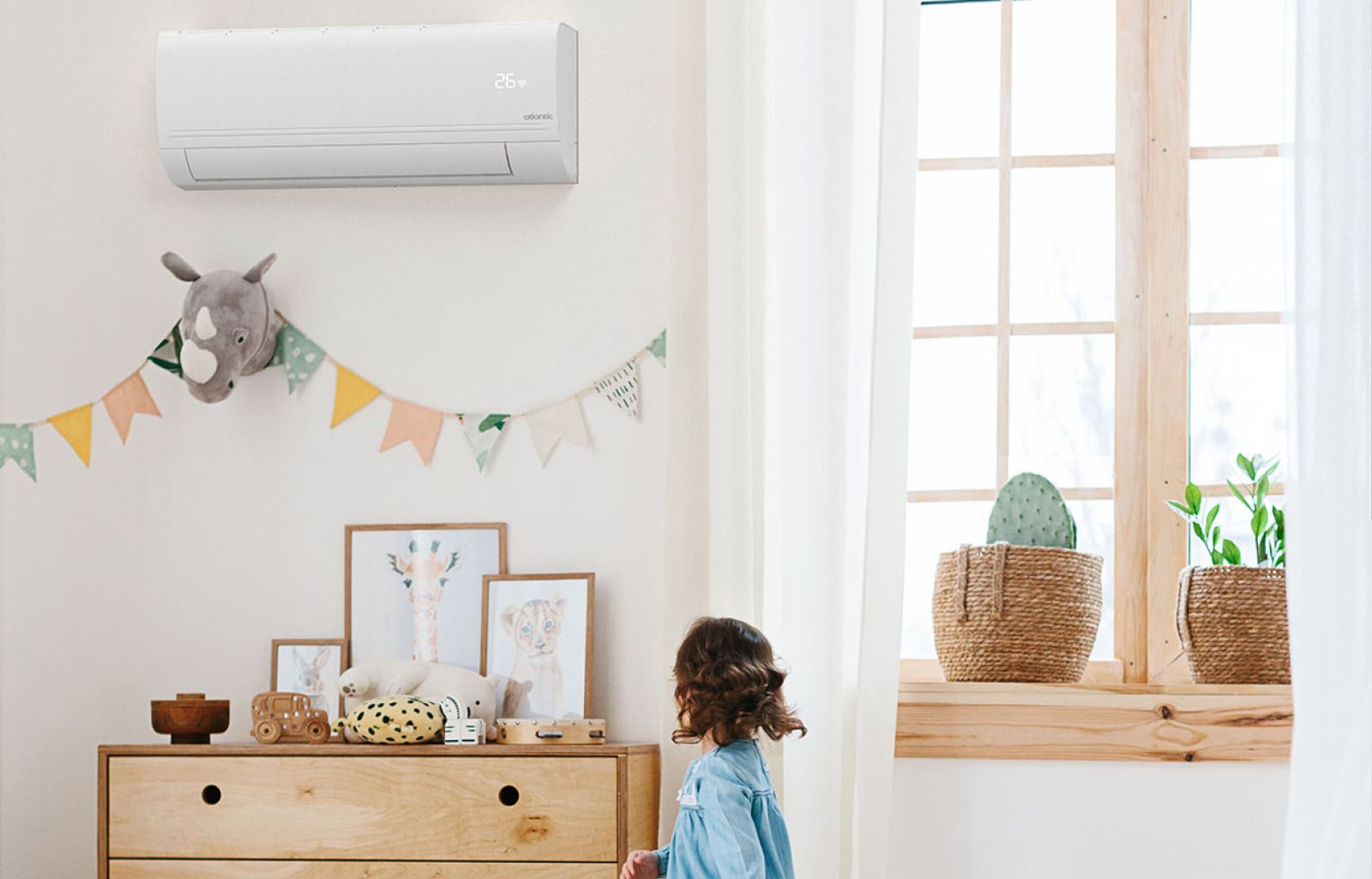 Un enfant se tient debout dans une chambre d'enfant lumineuse avec une commode, des décorations murales, des guirlandes et une fenêtre avec des plantes.