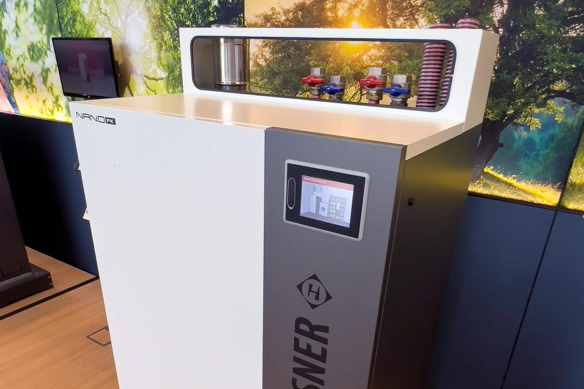 Kiosque moderne avec écran tactile et étagère supérieure présentant des articles colorés dans un environnement intérieur lumineux