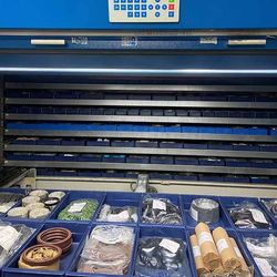 Un almacén lleno de muchos contenedores azules con diversos artículos.