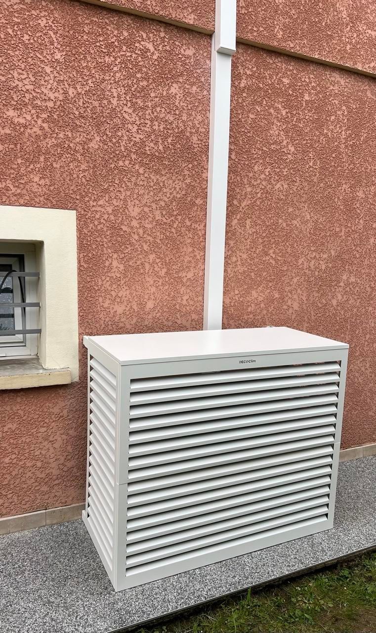 Une pompe à chaleur sur du crépi rouge