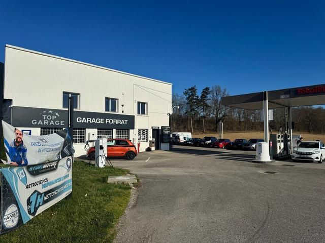 Un garage Top Garage avec une station-service sous un auvent, par une journée ensoleillée.