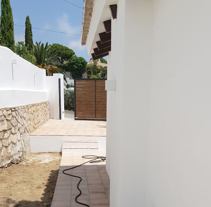 Una manguera está conectada al costado de un edificio.
