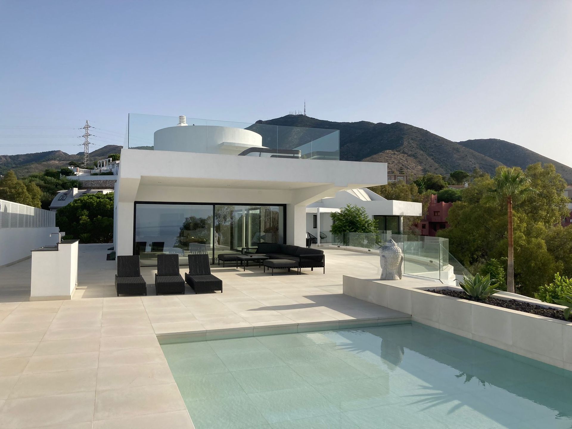Una gran casa blanca con una piscina delante de ella.