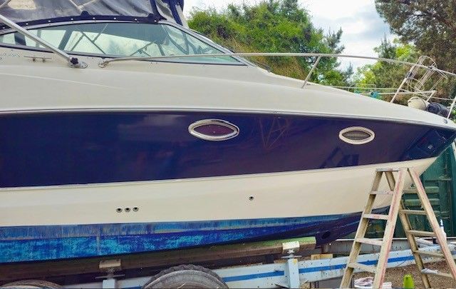 Ein Boot liegt auf einem Anhänger neben einer Leiter.