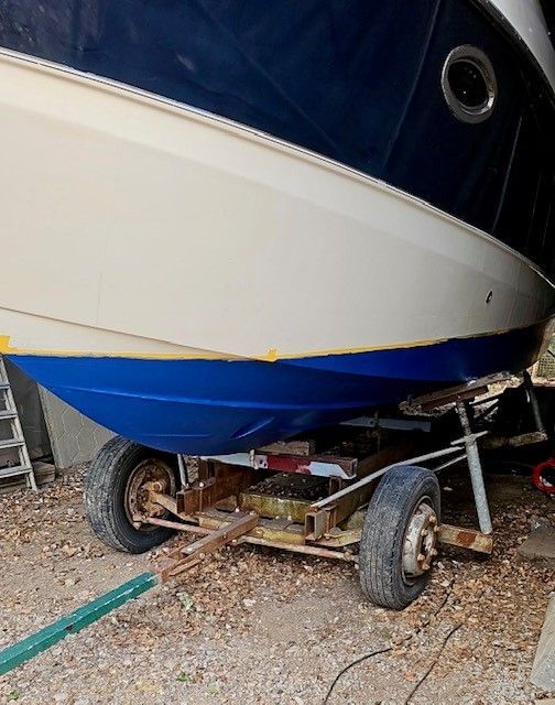 Ein blau-weißes Boot liegt auf einem Anhänger