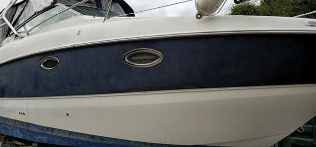 Ein weiß-blaues Boot liegt auf einem Dock.