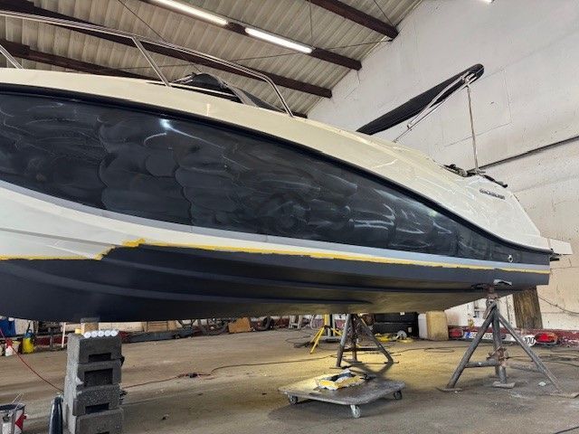 Ein Boot steht in einer Lagerhalle und wird gestrichen