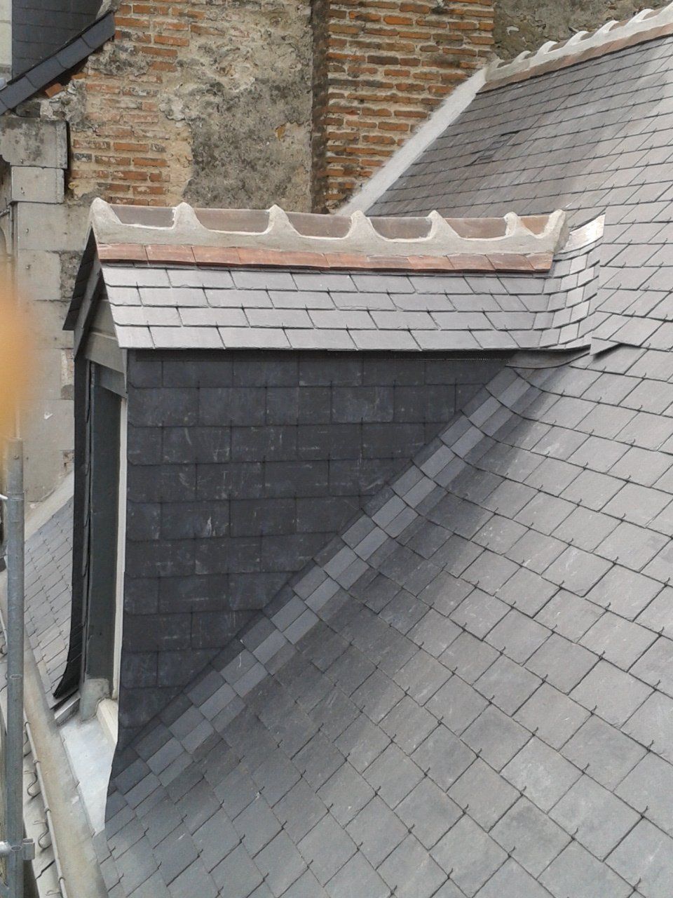 Gros plan sur une lucarne de toit recouverte d'ardoise