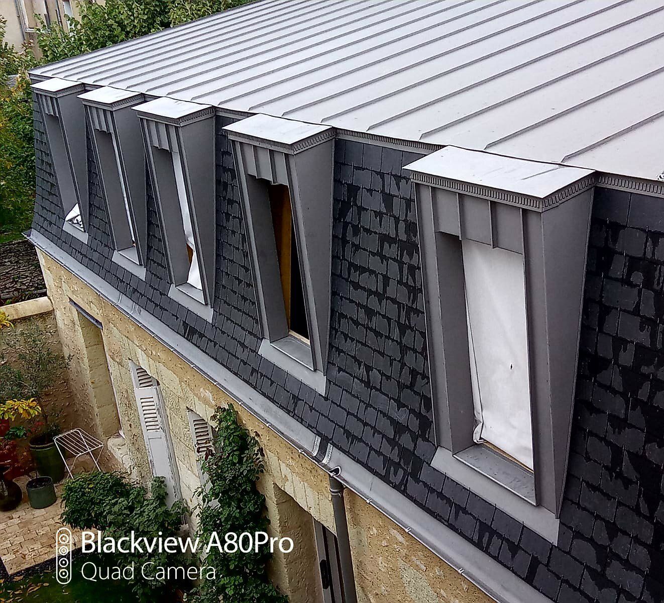 Couverture verticale en ardoise pour un bâtiment avec cinq fenêtres